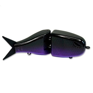 A two-piece jointed fishing lure shaped like a fish, featuring a glossy black top that fades into a purple on the sides, set against a plain white background.