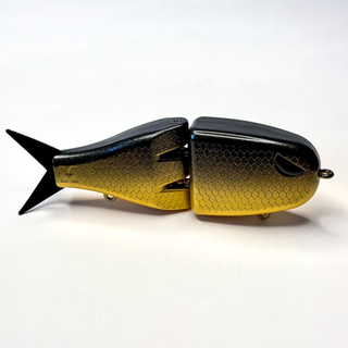 Gold and black fishing lure on a white background